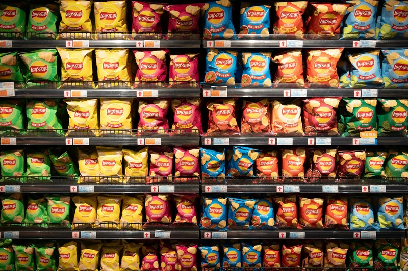 Pared de bolsas de patatas fritas en un supermercado